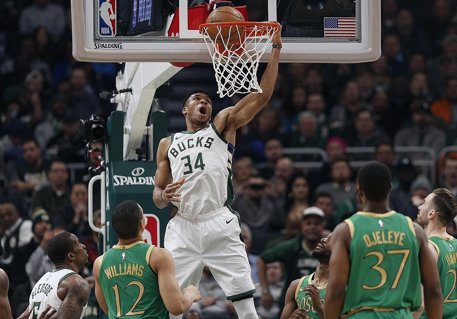 NBA MVP Giannis Antetokounmpo downing two of his 32 points in the Milwaukee Bucks' 128-123 win over the Boston Celtics on Thursday, which extended the Eastern Conference leaders' winning streak to five games.