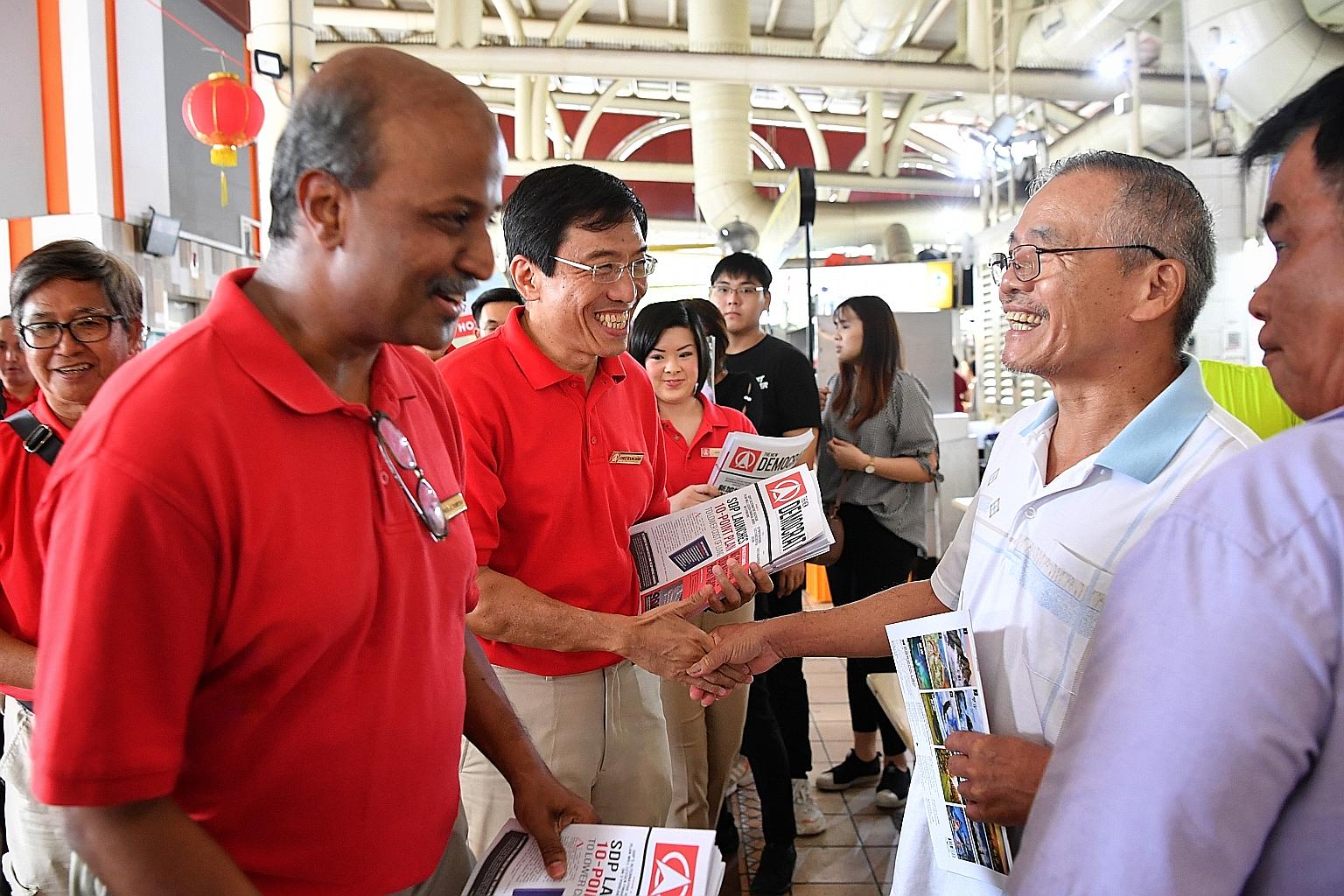 (From left) SDP chairman Paul Tambyah and secretary-general Chee Soon Juan at the Bukit Timah Market and Food Centre yesterday.