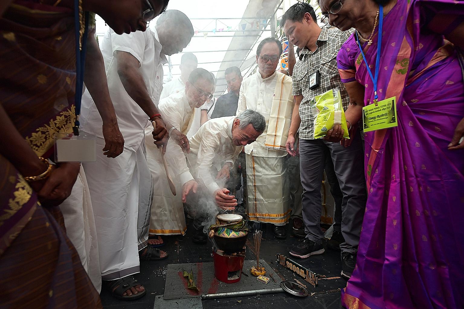 Prime Minister Lee Hsien Loong adding rice grains to a pot of boiling milk yesterday. During Pongal, cooking rice in fresh milk until the mix overflows from the pot symbolises abundance and fortune. The festivities were hosted by Bukit Panjang MP Teo