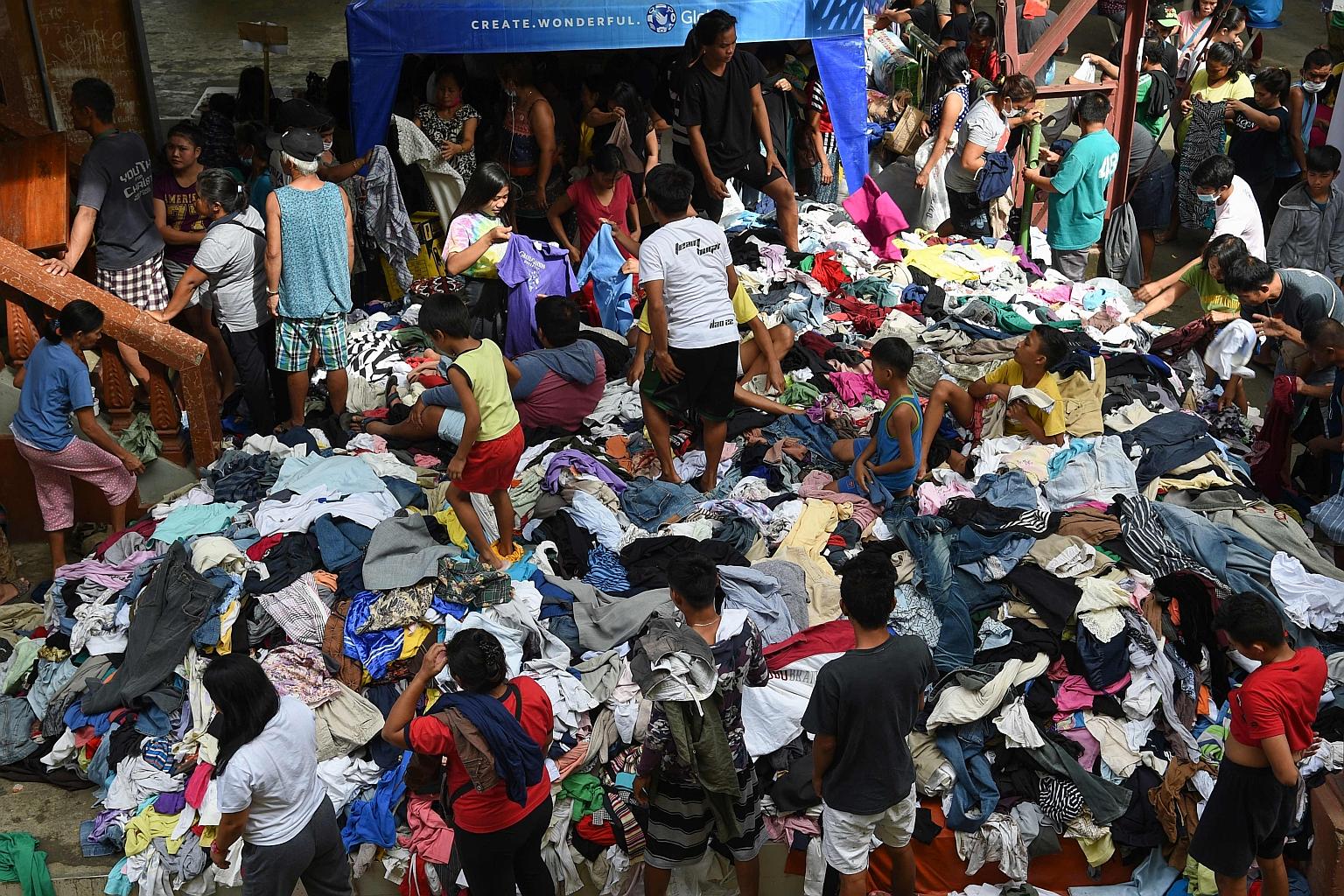 Evacuees affected by the eruption of Taal volcano sifting through donated clothes yesterday at an evacuation centre in Batangas province, south of the Philippine capital Manila. Seismologists have warned that the volcano could imminently unleash a mu