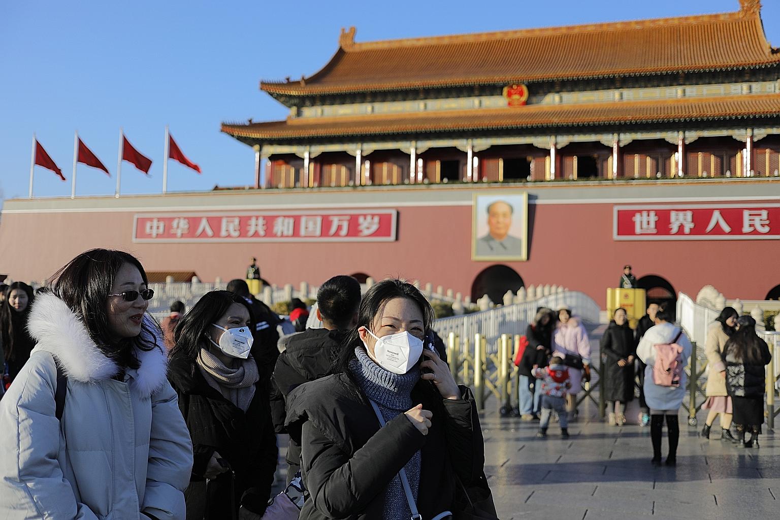 Chinese with masks on near Beijing's Tiananmen gate tower yesterday, as alarm spread on social media after the number of confirmed cases in the Wuhan outbreak trebled at the weekend. PHOTO: EPA-EFE