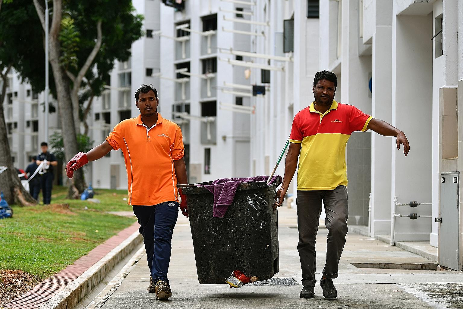 Two workers carrying the rubbish chute bin to the bin centre on Jan 7 after it had been checked. A baby boy was found alive in the bin at the bottom of a rubbish chute at Block 534 Bedok North Street 3 that morning.