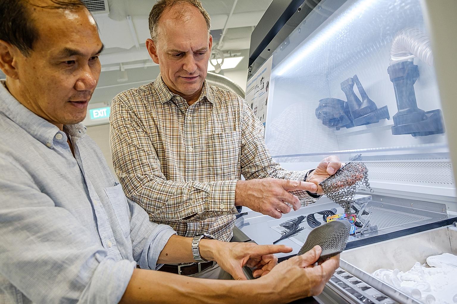 Co-directors of the HP-NTU Corporate Lab, NTU's Professor Tan Ming Jen (far left) and Dr Mike Regan, discussing the development of new intelligent design software tools that will speed up and optimise the printing process for a 3D printer.