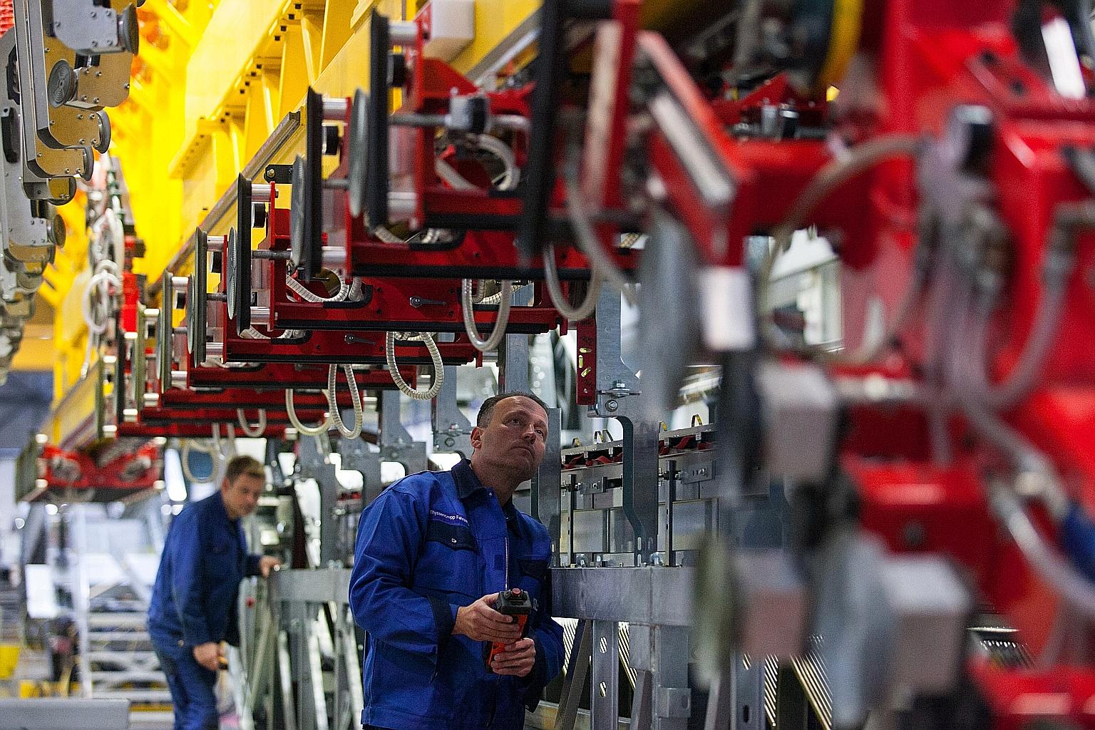 Employees at the Thyssenkrupp factory in Hamburg, Germany, working on assembling escalators. Brookfield Asset Management, which partnered Temasek, is still in the running for the elevator unit, say sources. PHOTO: BLOOMBERG