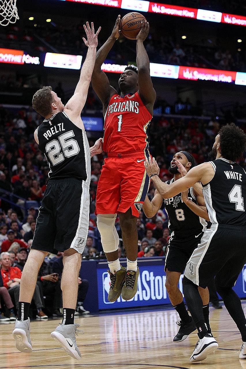 New Orleans Pelicans rookie Zion Williamson shooting over the Spurs' Jakob Poeltl at the Smoothie King Centre in New Orleans on Wednesday. The 19-year-old had a sizzling fourth quarter with 17 points, but the Pelicans eventually lost 121-117. PHOTO: 