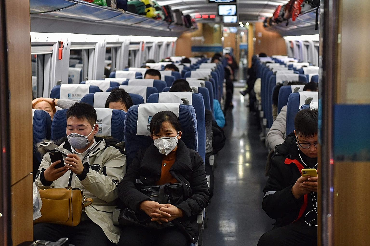 People wearing masks on a train in Shanghai yesterday. Wuhan's position on the confluence of the Yangtze River and the Han River means it has long been a key transport node linking the rest of China. PHOTO: AGENCE FRANCE-PRESSE