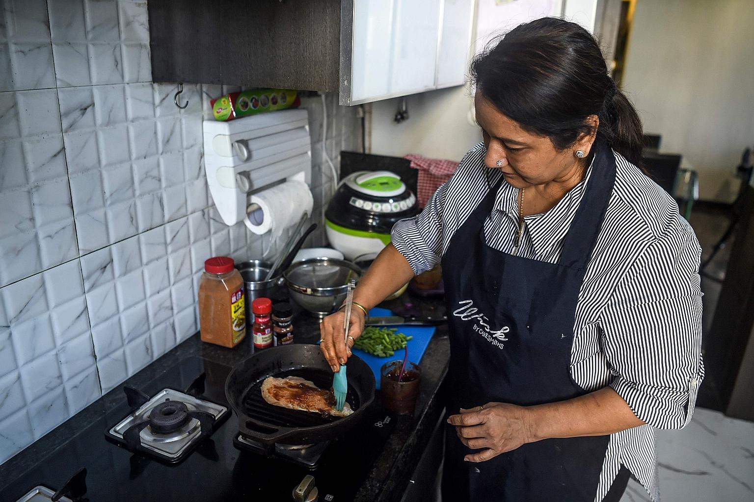 Madam Rashmi Sahijwala preparing a dish in her kitchen in Mumbai. New apps like Curryful, Homefoodi and Nanighar are giving Indian housewives - many of whom have long struggled to convince conservative families to let them leave home - an opportunity