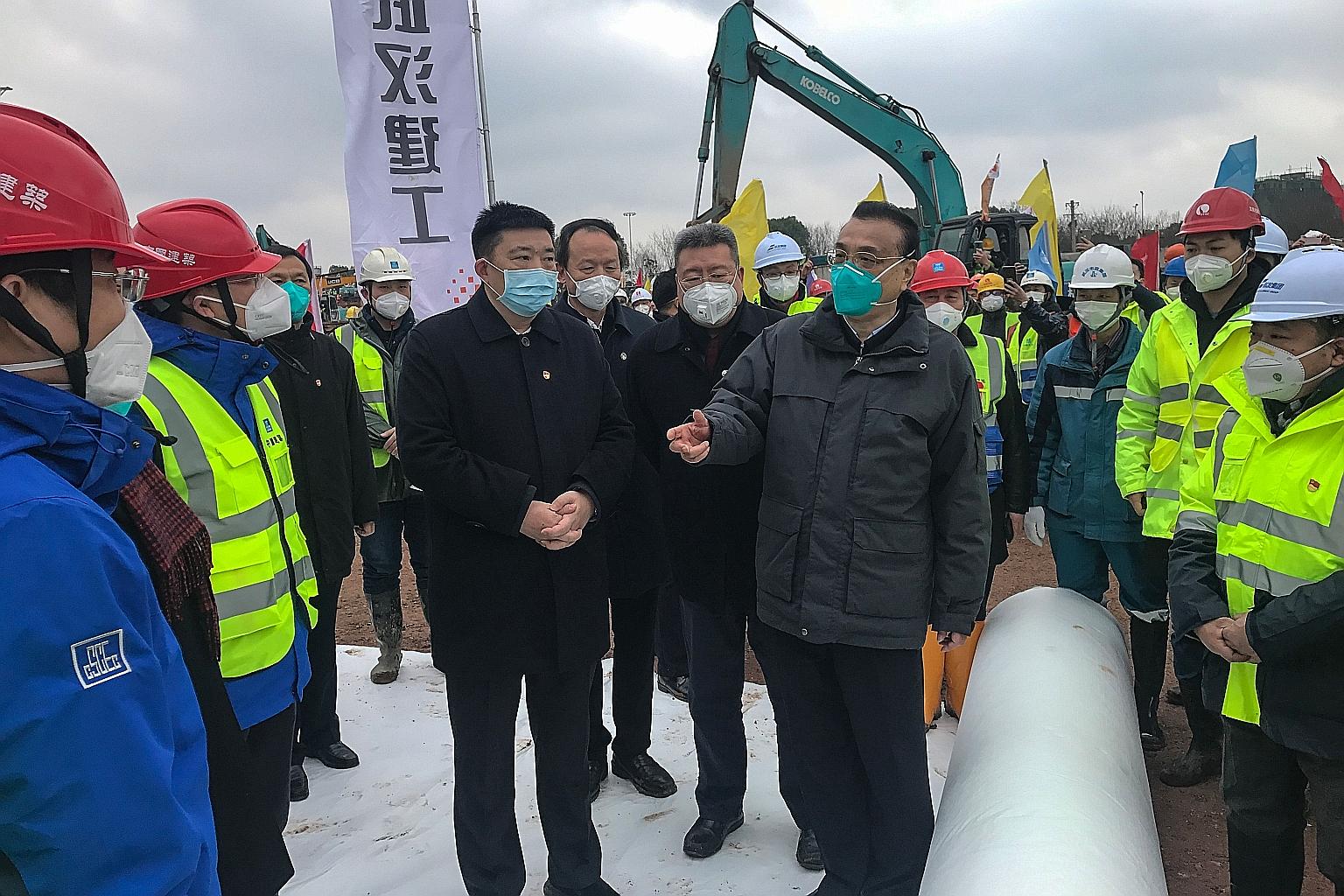 Chinese Premier Li Keqiang (centre) addressing workers at the construction site of a new hospital being built to treat patients of the novel coronavirus in Wuhan, capital of Hubei province, yesterday. During a visit to several sites in Wuhan yesterda