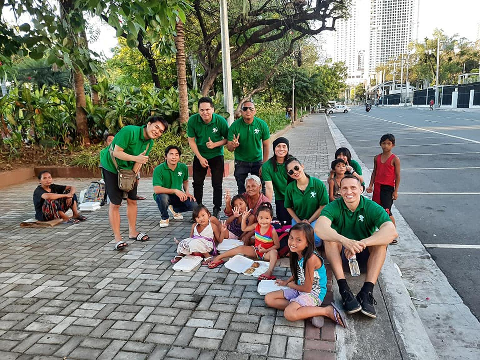 Volunteers from the Robin Hood Army serving food to poor children in Bangalore (above) and to the homeless in the Philippines (below). The Indian non-profit has a zero-funds approach and is volunteer-driven. PHOTOS: ROBIN HOOD ARMY