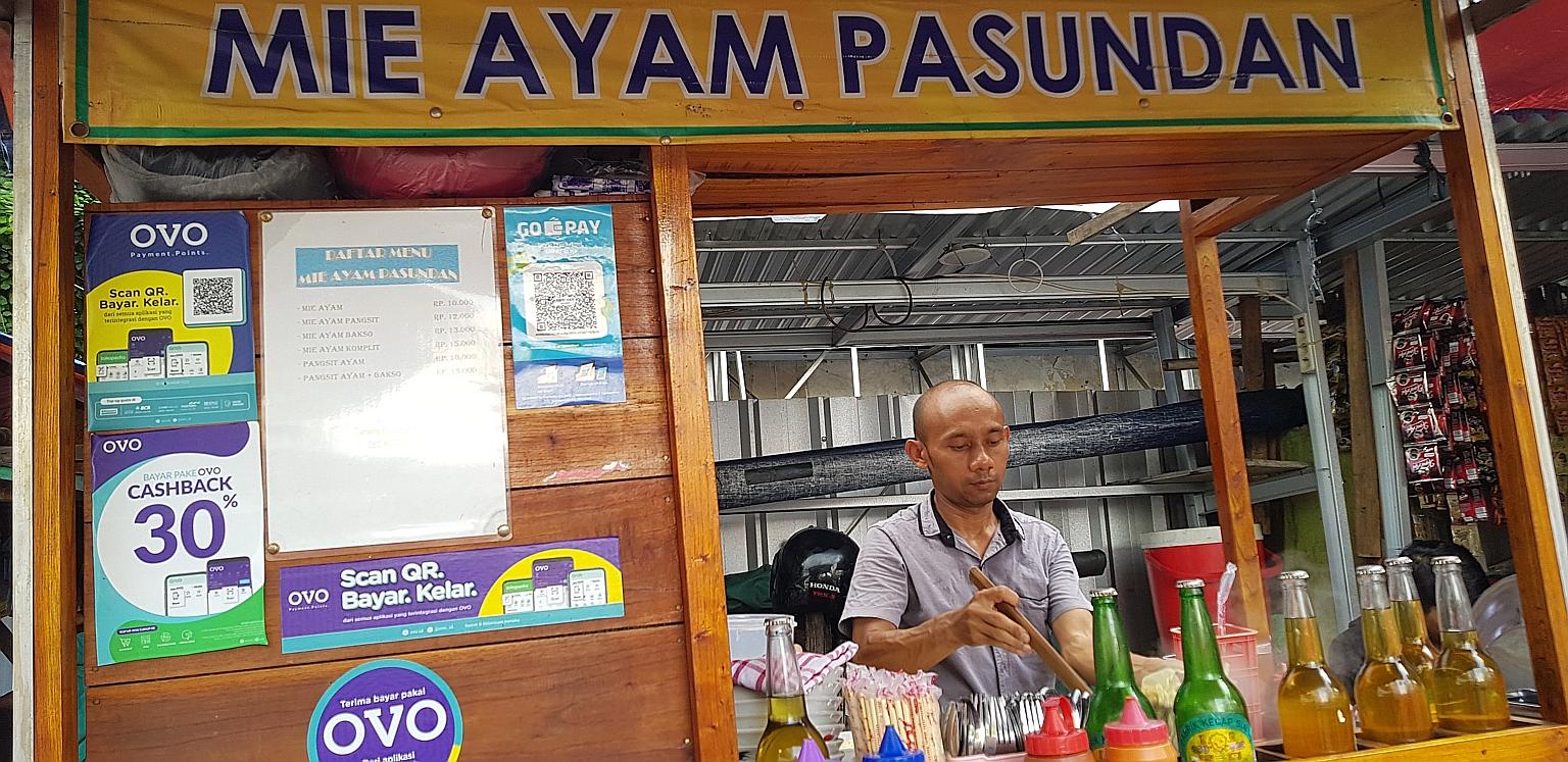 A noodle street vendor in Indonesia that accepts payment from e-wallets Go-Pay and Ovo. At least 39 e-wallet apps have been licensed by the central bank. The total value of transactions made through e-wallets was US$1.5 billion (S$2 billion) in 2018,