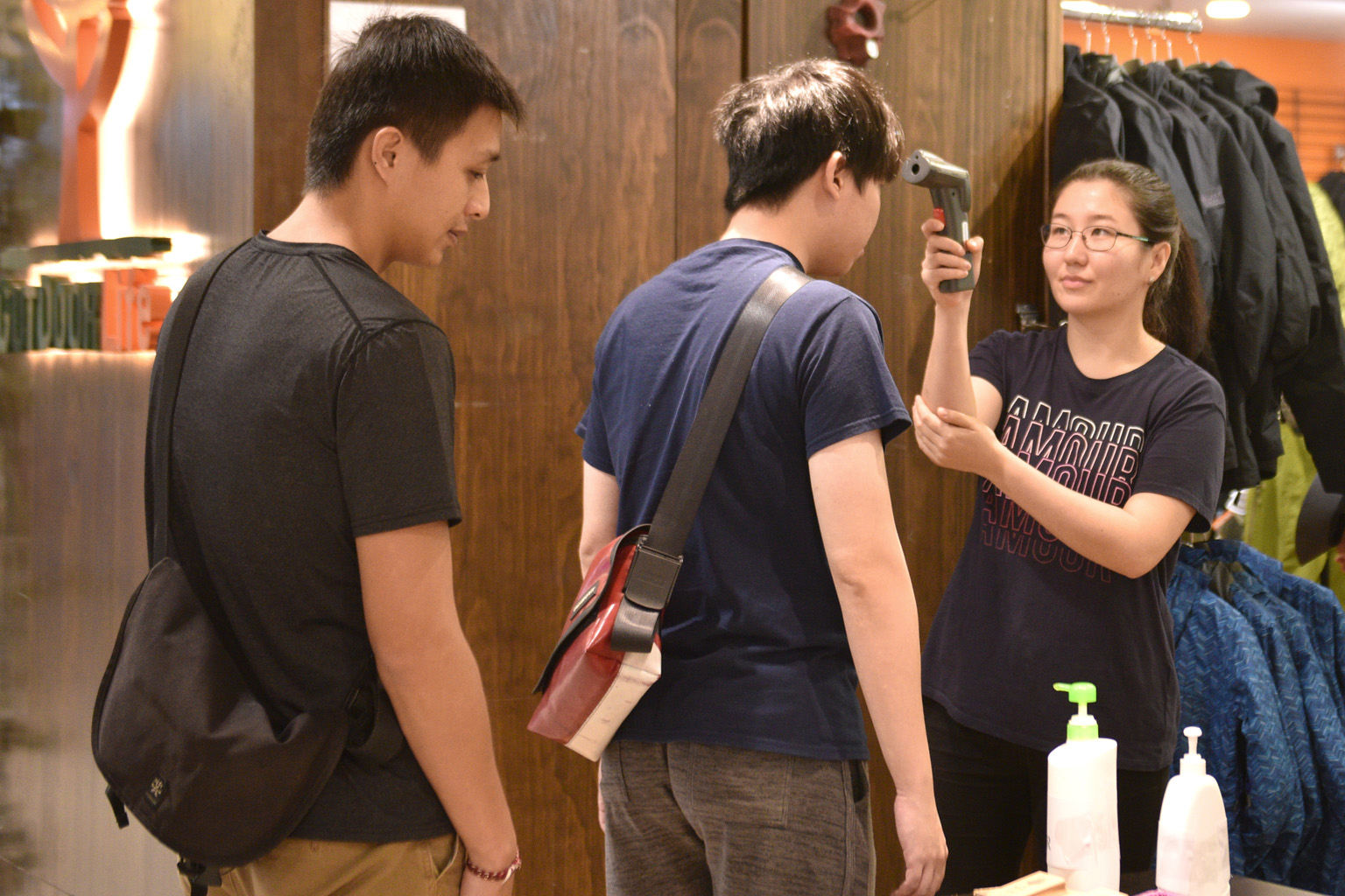 An employee at retail store Outdoor Life at Plaza Singapura checking a customer for fever on Sunday. Several businessmen told The Straits Times that their firms have taken steps in response to the outbreak. ST PHOTO: KELLY HUI
