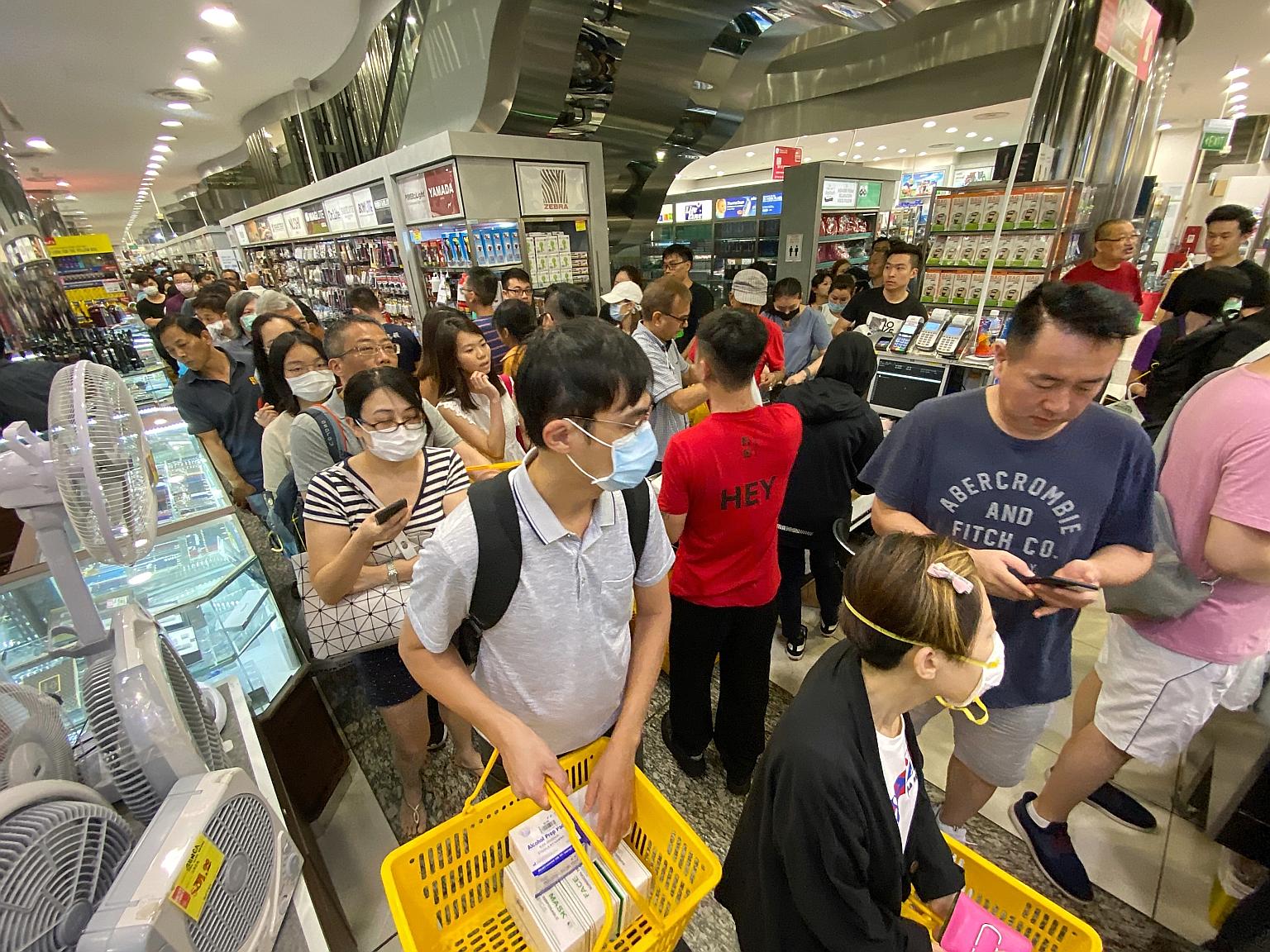 People queueing to buy boxes of masks at Mustafa Centre yesterday. Senior Minister of State for Health Lam Pin Min said there are enough masks if people use them sensibly.