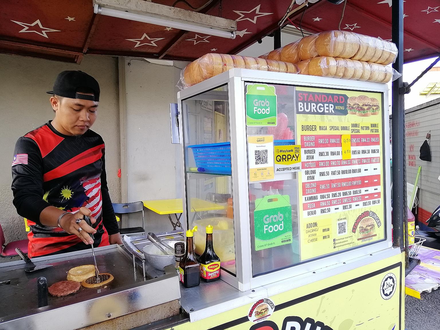 A roadside burger stall in Kuala Lumpur that accepts e-wallet payments. As part of its drive to promote e-payments, the Malaysian government is collaborating with GrabPay, Touch 'n Go eWallet and Boost to give RM30 worth of free shopping money for ea