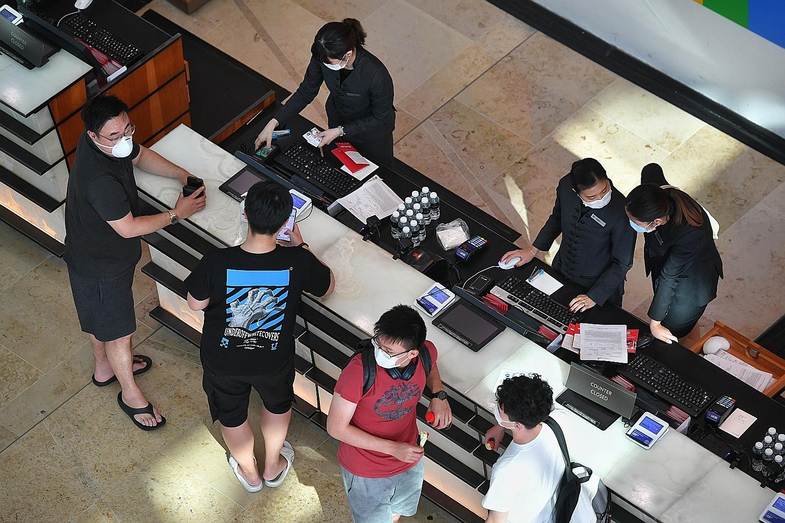Marina Bay Sands staff wearing masks while attending to hotel guests. At firms like OCBC Bank, masks are distributed to all front-line staff. The cleaning regime in common areas is also being stepped up.