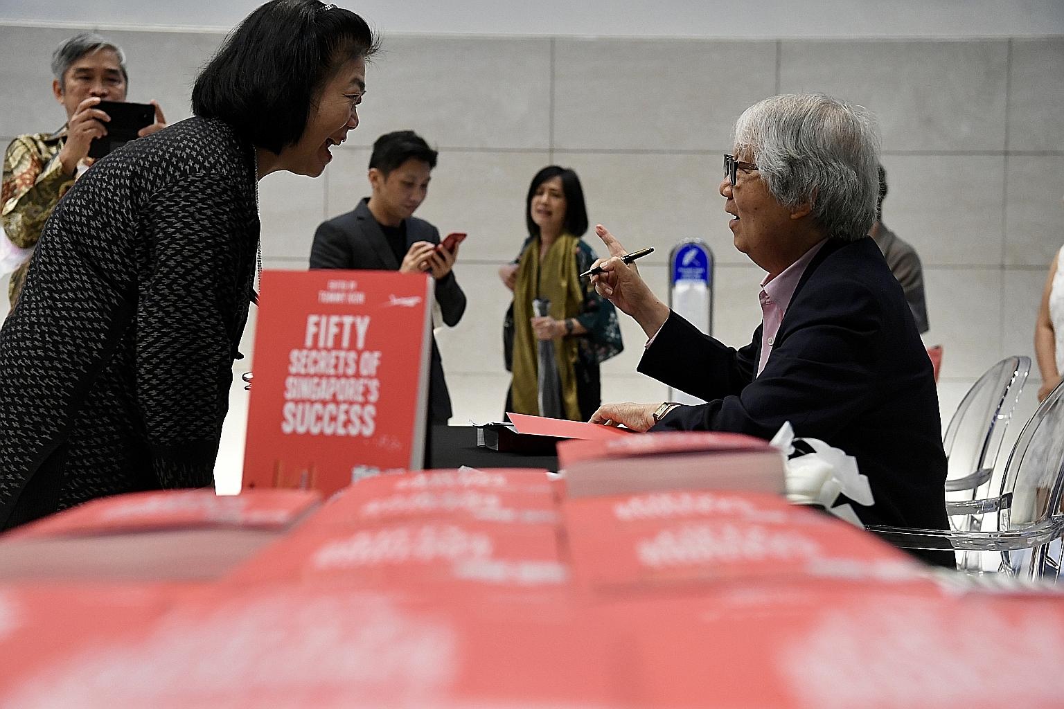 Professor Tommy Koh chatting with a reader at the launch of Fifty Secrets Of Singapore's Success at the National Museum of Singapore yesterday. Fifty Secrets Of Singapore's Success is available for $37.45 at all major bookshops and online at shop.sph