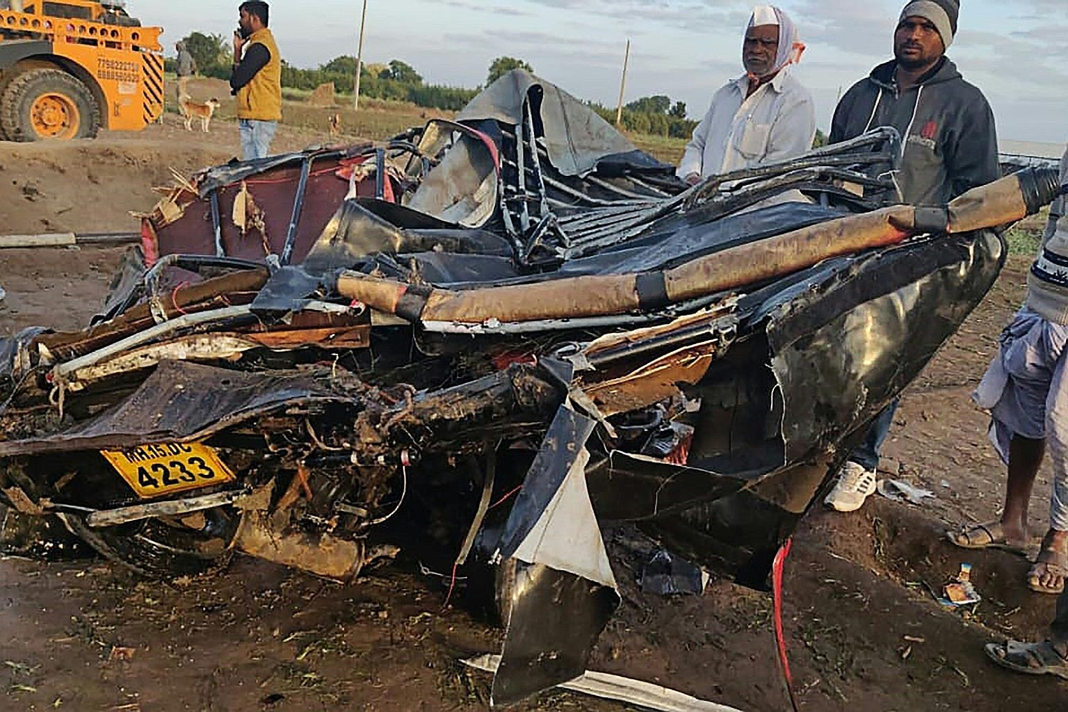 Onlookers gathering around the crumpled remains of an auto rickshaw (above) that crashed with a bus in Nashik district, near Mumbai, on Tuesday. A seven-year-old girl was among the dead after the bus fell into a well.