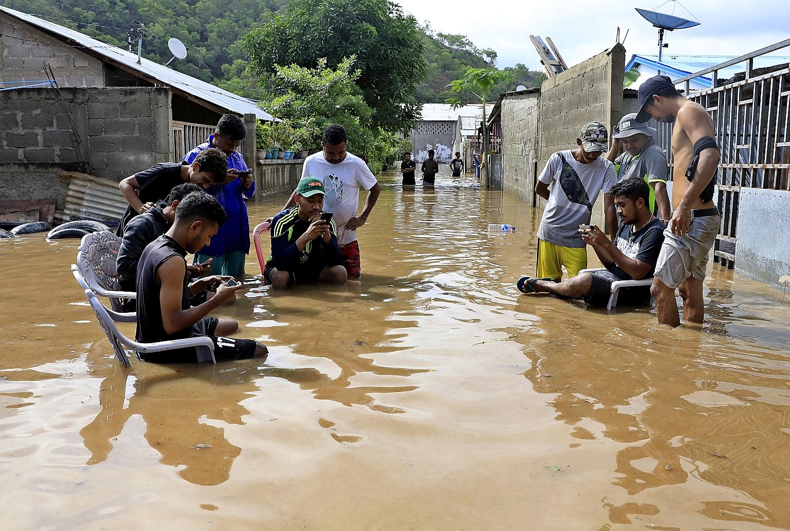 Life goes on as usual for these people in a flooded street after heavy rain hit parts of Dili city in East Timor last week. A report issued last week by the Bank for International Settlements warned that central bankers lack the tools to deal with wh