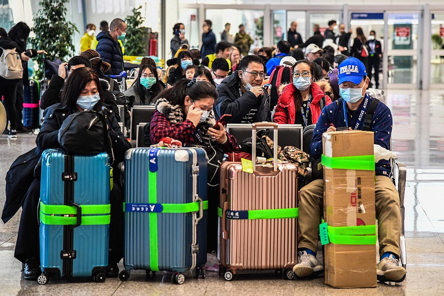 Passengers waiting to board a flight yesterday at Rome's Fiumicino airport, as a number of airlines halted or reduced flights to China in a bid to contain the spread of the Wuhan coronavirus. China sent two planes to Malaysia and Thailand yesterday t