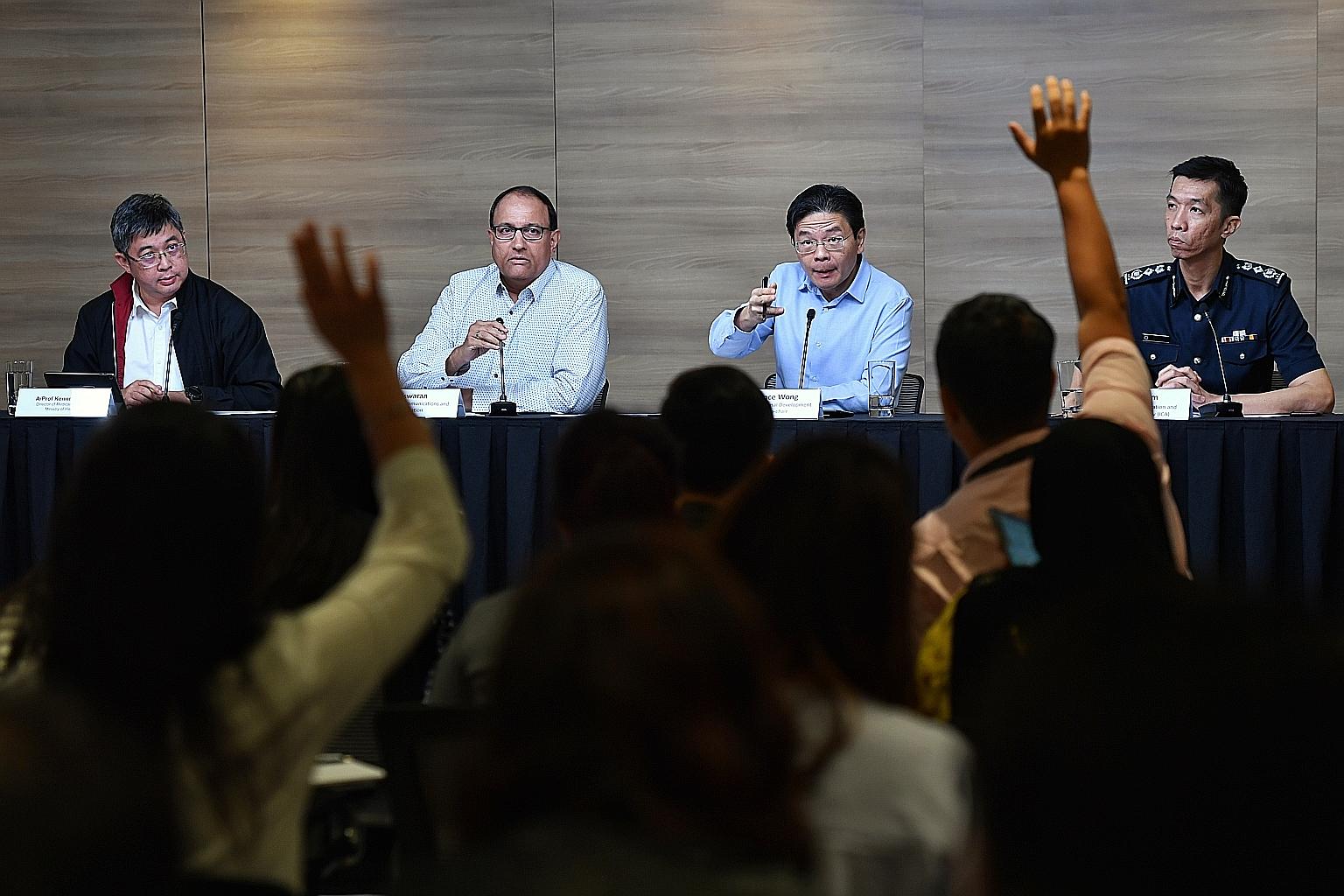 Below, from left: Ministry of Health director of medical services Kenneth Mak, Communications and Information Minister S. Iswaran, National Development Minister Lawrence Wong, and Immigration and Checkpoints Authority Commissioner Marvin Sim at a new