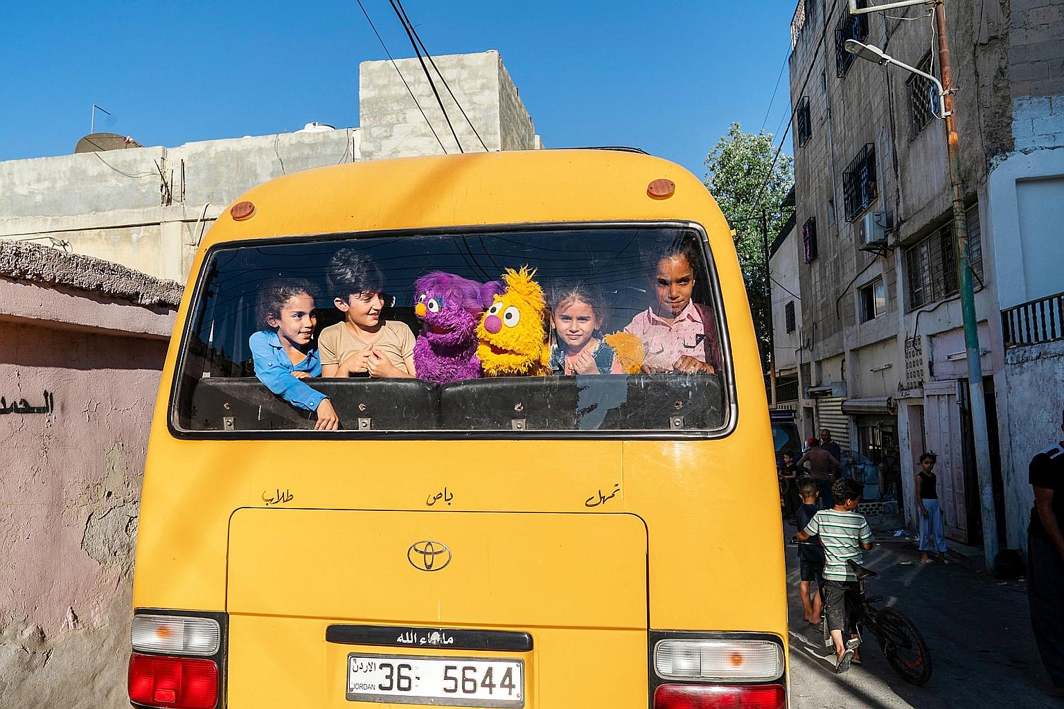 Characters Basma (left) and Jad, from a new Middle East version of Sesame Street, taking a bus with children in Amman, Jordan. The show seeks to help children, especially young Syrian refugees, cope with emotions.