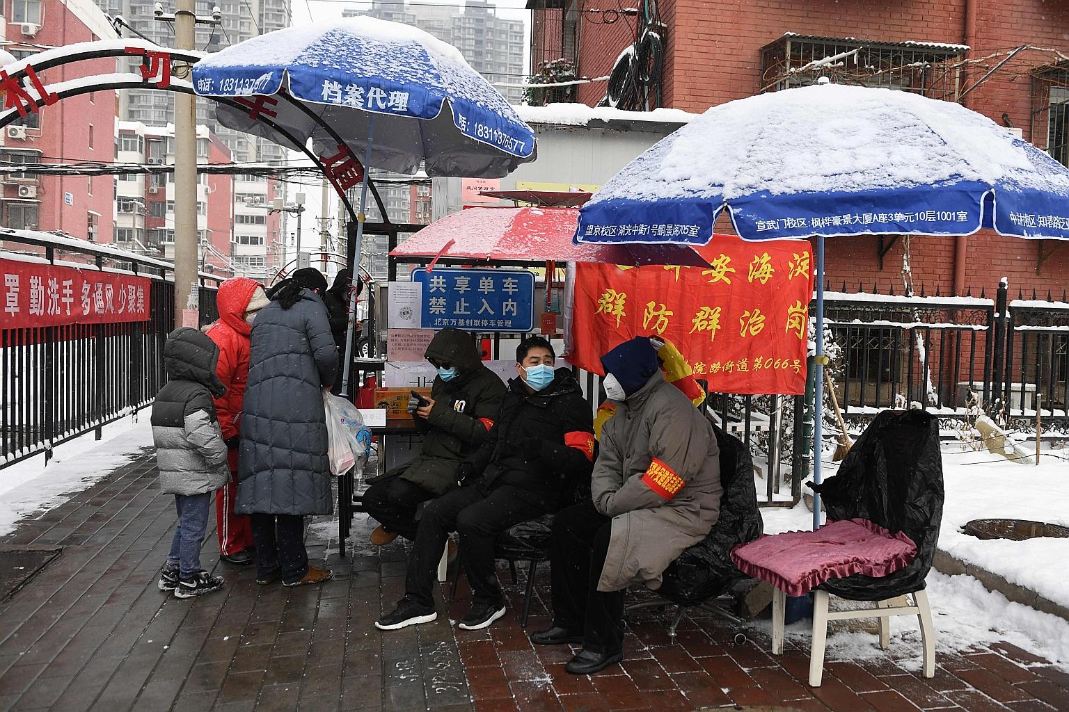 Residents monitoring the entrance to a residential compound in Beijing yesterday. Most Chinese are living in fear and staying home, but there is no widespread chaos or mass exodus - a sign that the Communist Party's credibility is pretty much intact.