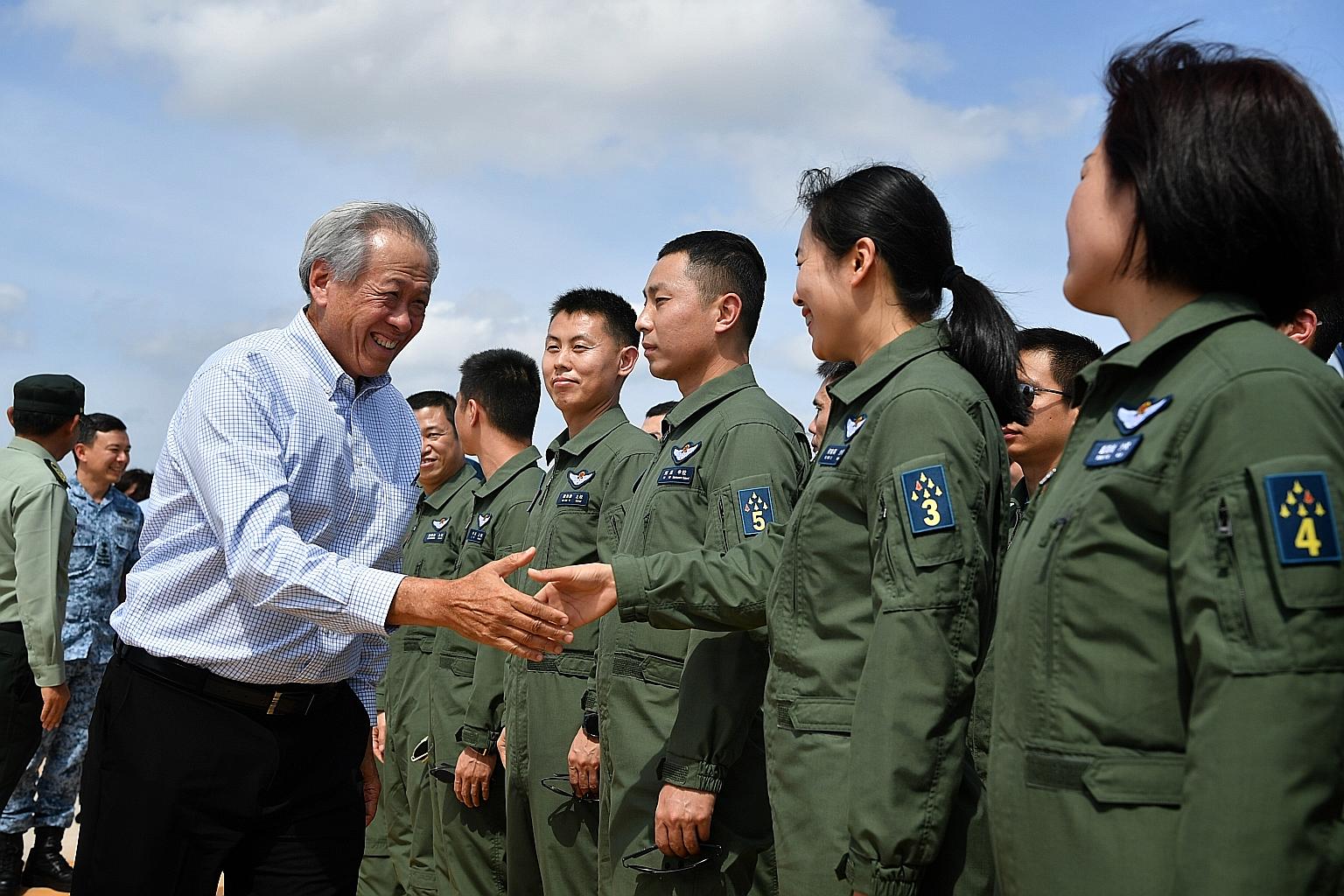 Defence Minister Ng Eng Hen meeting members of the People's Liberation Army's Ba Yi aerobatics team at Changi Air Base (East) yesterday. The team is taking part in the airshow for the first time as one of five flying display performances.