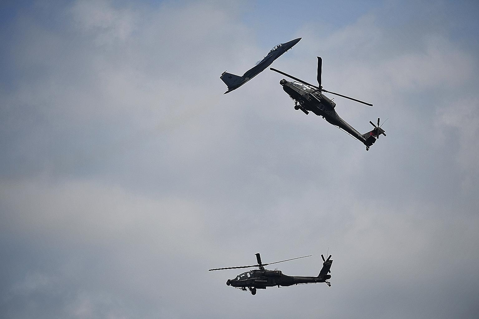 An aerial display by an F-15SG fighter plane and two AH-64D helicopters during an RSAF preview yesterday. The airshow will be held at the Changi Exhibition Centre from next Tuesday, and is open to the public on Feb 15 and Feb 16.