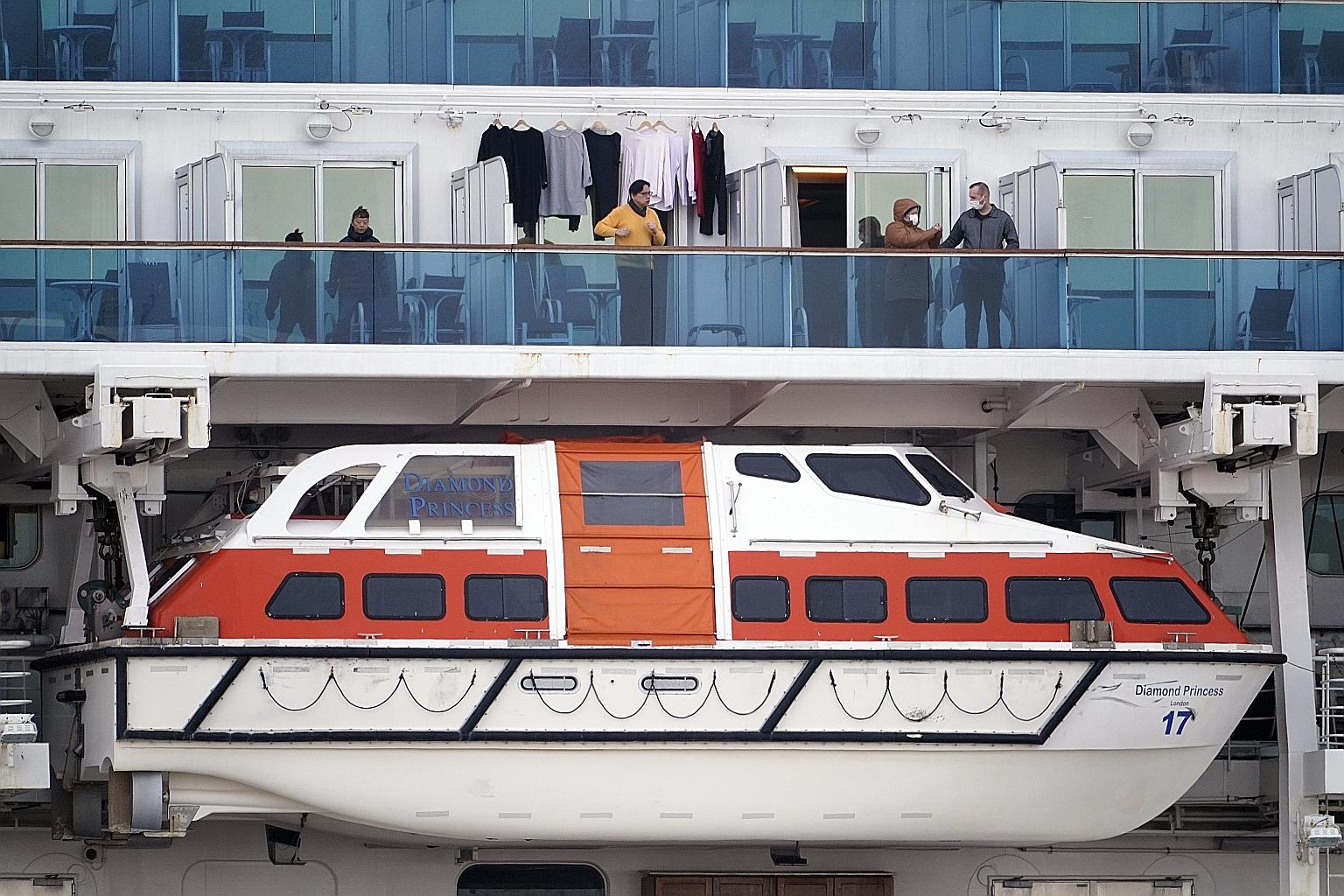 Diamond Princess passengers standing at their cabin balconies off Yokohama yesterday. Sick passengers have been taken to hospitals across Tokyo, Kanagawa, Chiba, Saitama and Shizuoka prefectures for treatment. The remaining passengers and crew member