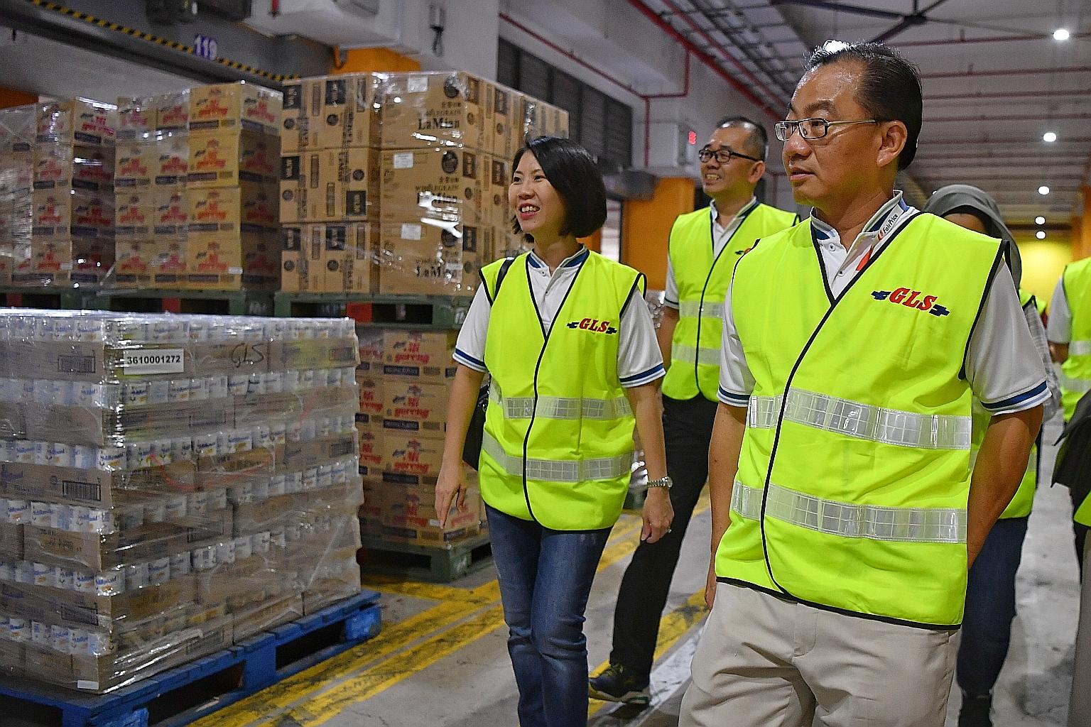 FairPrice group chief executive Seah Kian Peng (at right) visiting FairPrice's Benoi Distribution Centre yesterday. FairPrice has increased the volume of daily essentials being sent to the stores by three times. ST PHOTO: CHONG JUN LIANG