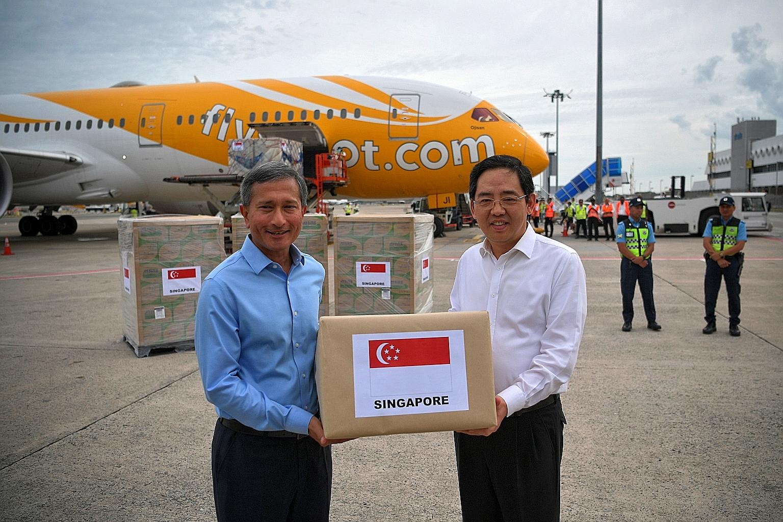 Dr Vivian Balakrishnan handing over diagnostic test kits and medical supplies to Chinese Ambassador Hong Xiaoyong yesterday.
