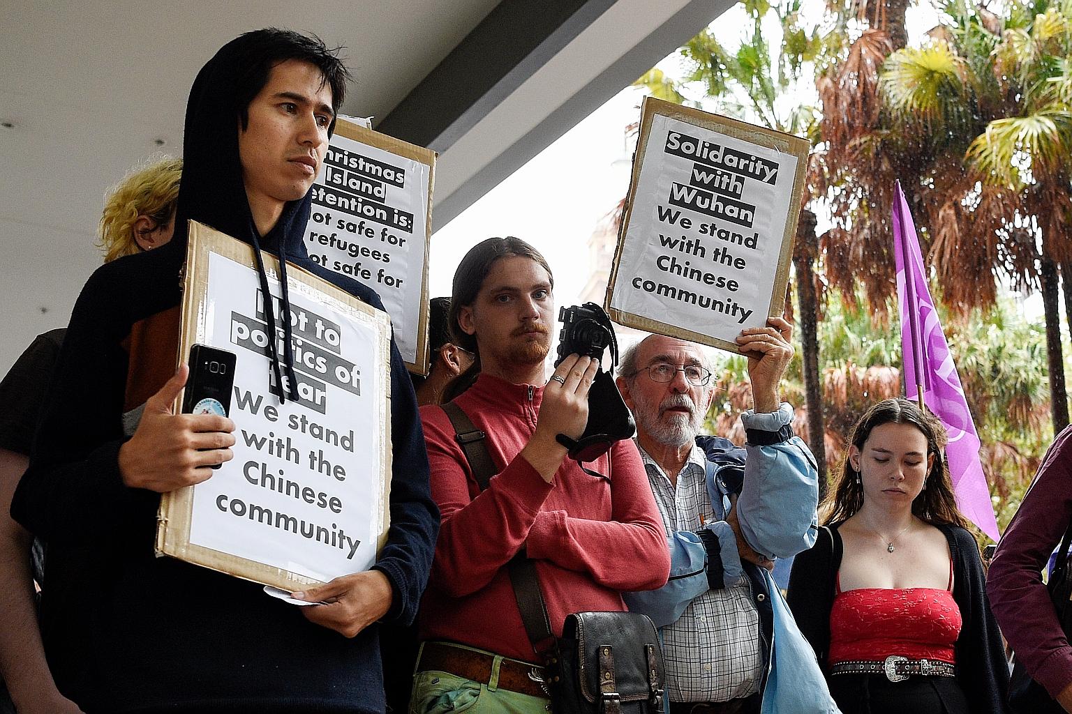 Protesters in Sydney holding placards outside the Department of Immigration and Border Protection during a rally against an inbound travel ban on foreign travellers from China. PHOTO: EPA-EFE