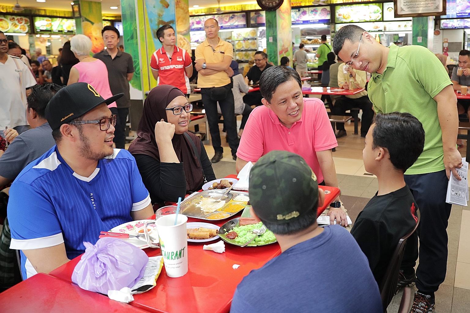 Trade and Industry Minister Chan Chun Sing (in pink) and Minister for Social and Family Development Desmond Lee (in green), who is also adviser to Jurong GRC grassroots organisations, speaking to residents during a ministerial community walkabout in 