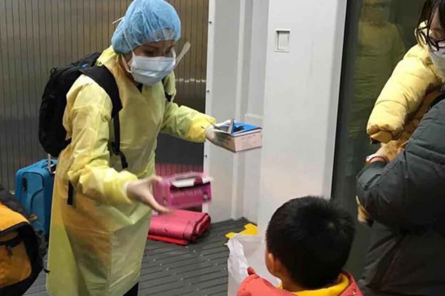 Ministry of Foreign Affairs staff handing out masks to the 174 Singaporeans and their family members before they boarded the flight taking them home from the Chinese city of Wuhan yesterday.