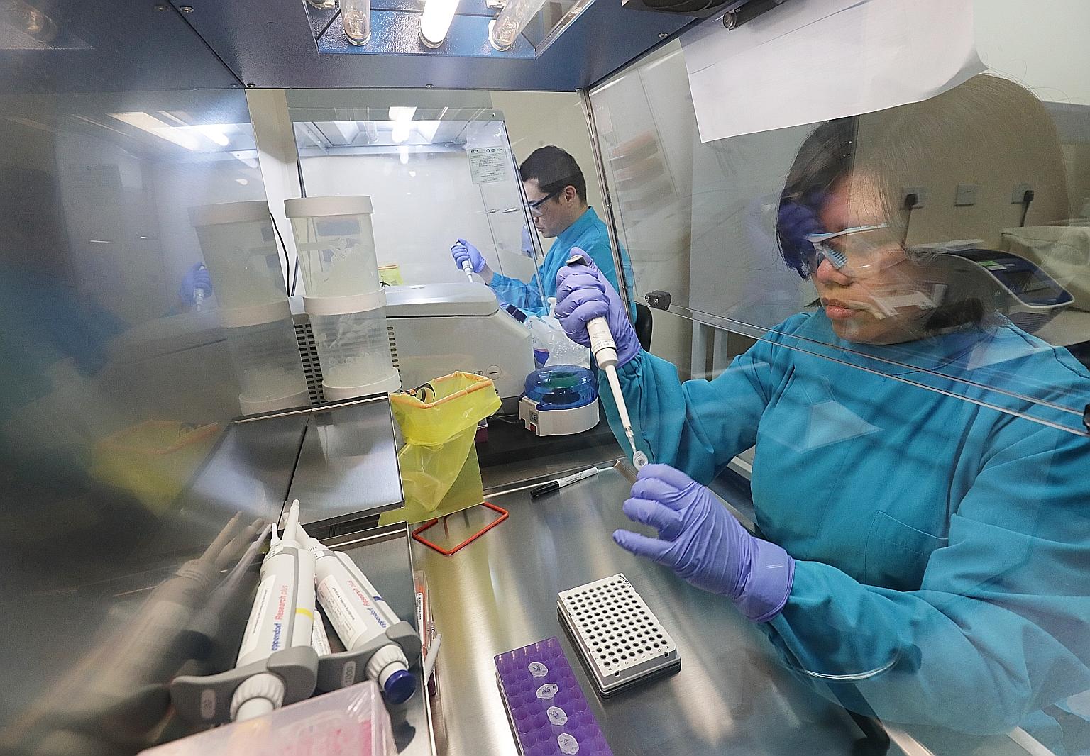 Laboratory technicians working on a diagnostic kit to test whether patients have the coronavirus at the Agency for Science, Technology and Research's Diagnostics Development Hub yesterday.
