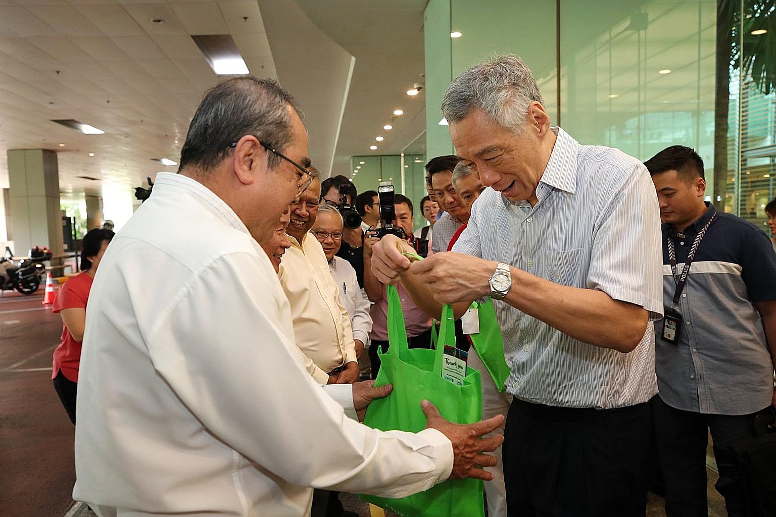 Prime Minister Lee Hsien Loong handing out care packages to taxi drivers at Changi Airport yesterday to thank them for continuing to ferry passengers amid the coronavirus outbreak. PHOTO: LEE HSIEN LOONG/FACEBOOK