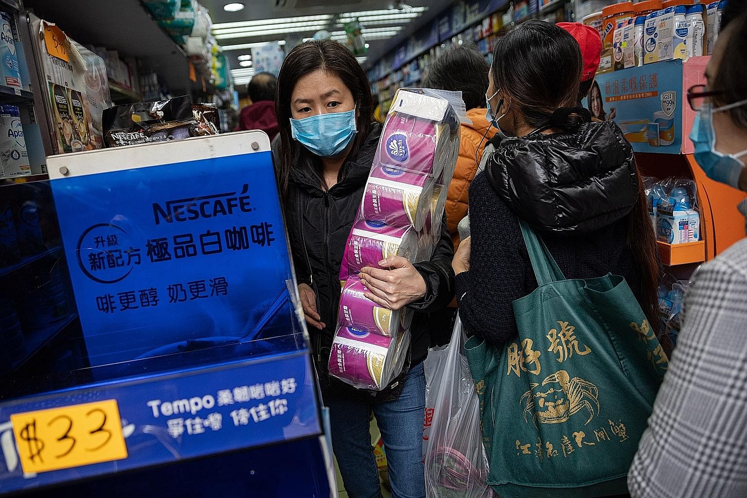 A shopper stocking up on toilet paper at a drugstore in Hong Kong. Threats that feel out of control, like a runaway illness outbreak, lead people to seek ways to re-impose control, for instance by hoarding supplies.