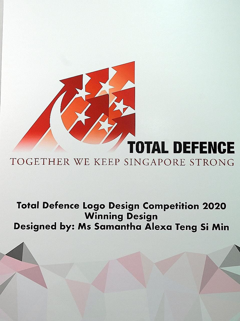 Minister for Trade and Industry Chan Chun Sing chatting with Ms Samantha Alexa Teng (right), the winner of the Total Defence Logo Design Competition 2020 (below). Beside him is Colonel Jerica Goh, director of Nexus, the Ministry of Defence's central 