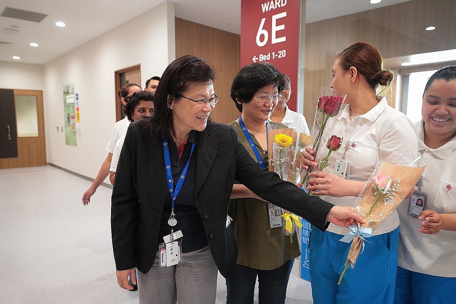 NCID executive director Leo Yee Sin with flowers for her staff from the public. With her are (from left) director of nursing Margaret Soon and nurses Ma. Olivia Valencia Valiente and Nurul Hazirah Subari.