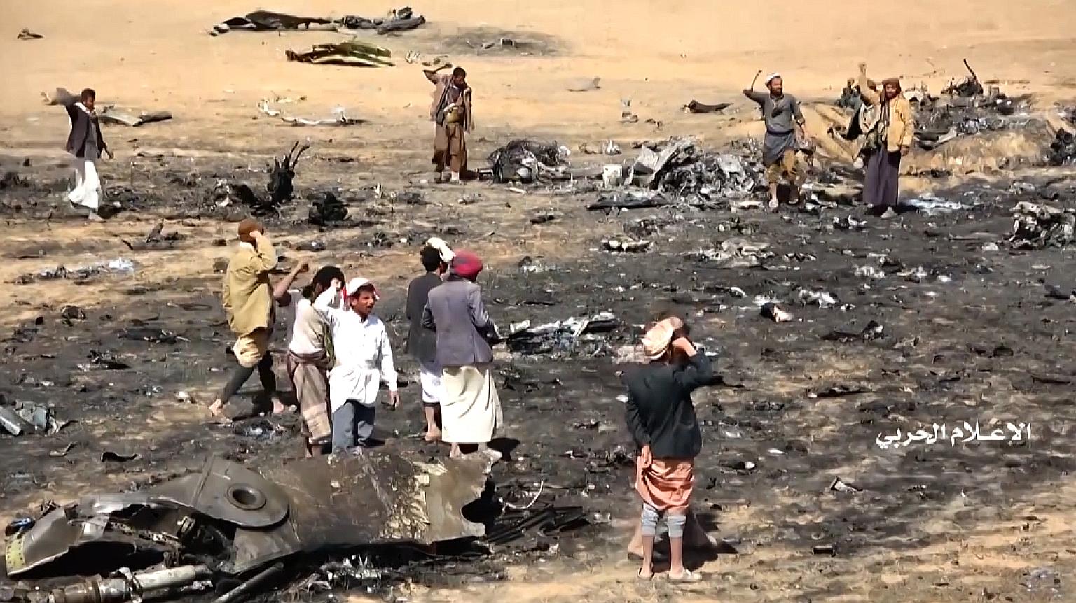 A screen grab from a video released by the Houthi Military Media Office on Saturday showing Yemenis gathering at the site of the downed Saudi Tornado aircraft in Yemen's northern Al-Jawf province.