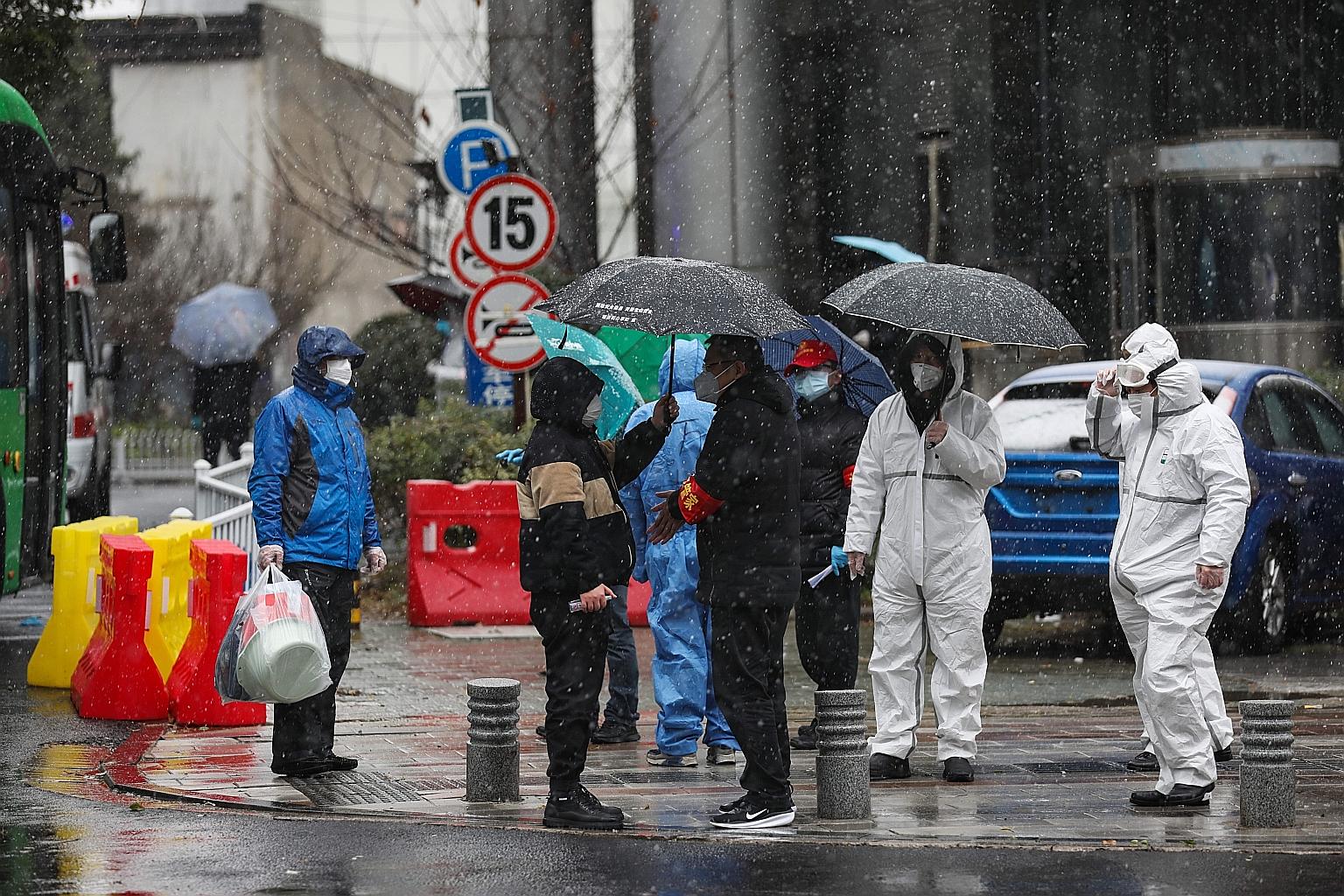 Medical staff and government workers waiting for patients to arrive, outside a hospital just designated to take in critical coronavirus patients in Wuhan, Hubei province, on Saturday.