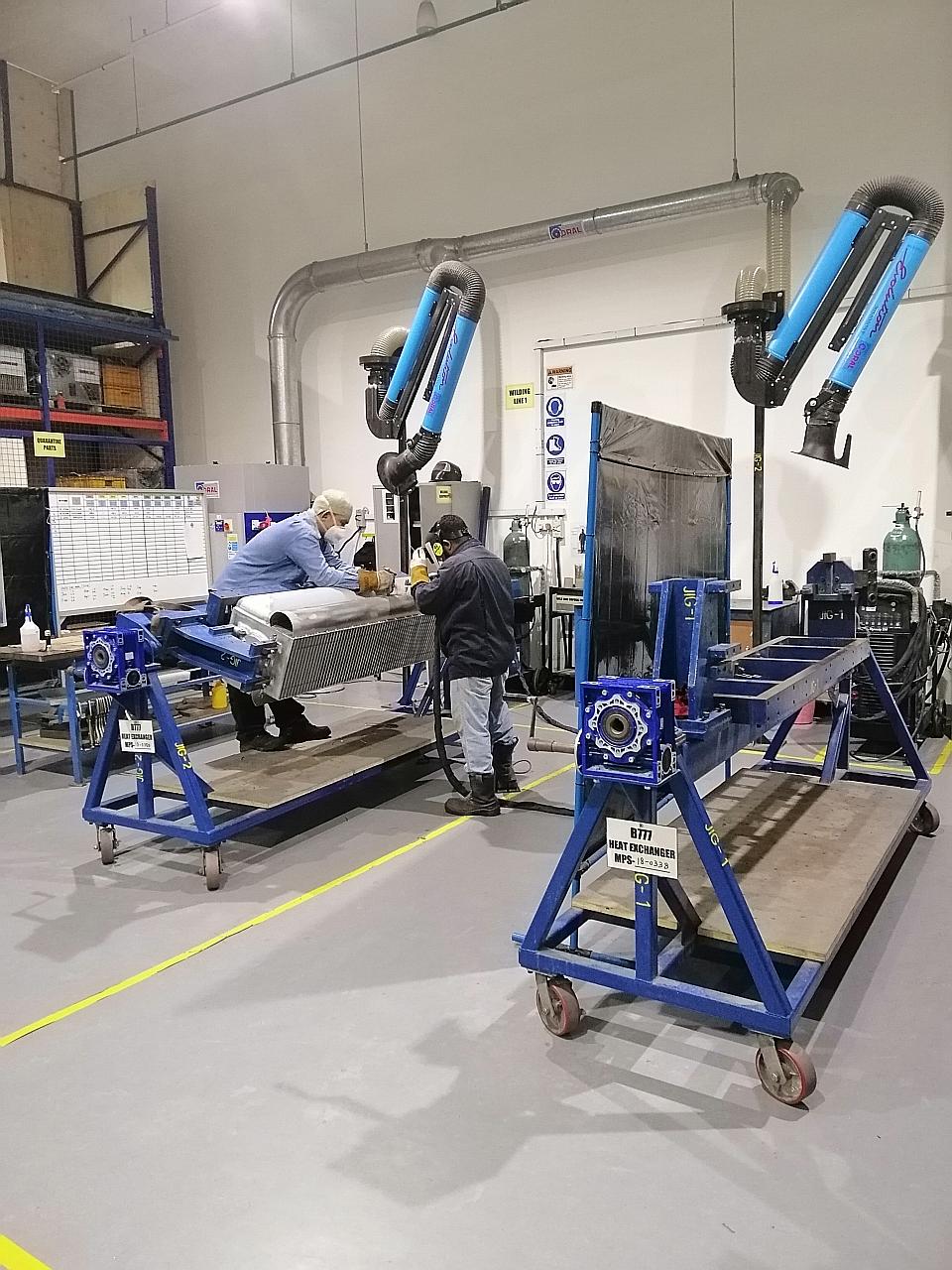 Workers welding on aircraft components at Coway Engineering's facility. The firm has invested more than $1 million over the past two years on initiatives to boost productivity, such as a vertical lean storage system that uses a carousel to transport