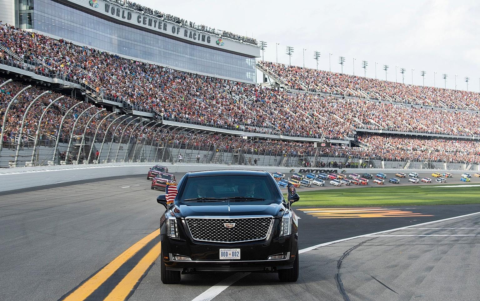 US President Donald Trump making a lap around the racetrack in his presidential limousine, with race cars following behind, at the Daytona International Speedway in Florida on Sunday. PHOTO: AGENCE FRANCE-PRESSE