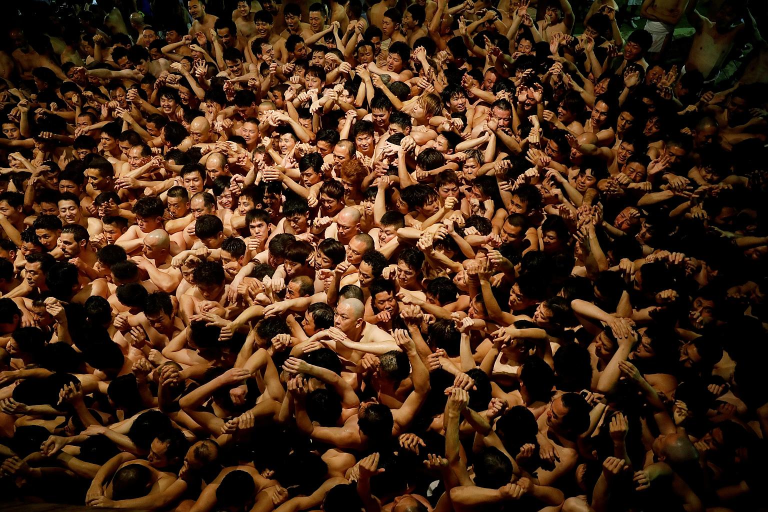 Men in loincloths jostling to snatch a lucky charm tossed by a priest at a festival at Saidaiji Temple in Okayama, in western Japan, last Saturday. Japan has seen a surge in the number of cases of infection, from 29 last Thursday to 66 as of last nig