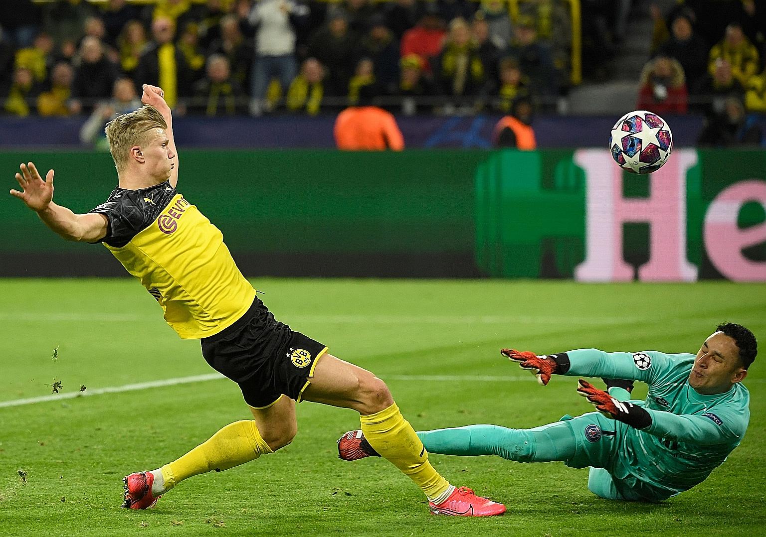 Erling Braut Haaland lifting the ball over PSG goalkeeper Keylor Navas to score the first goal. Dortmund have the edge in the tie after the Norwegian teenager's two goals. PHOTO: AGENCE FRANCE-PRESSE