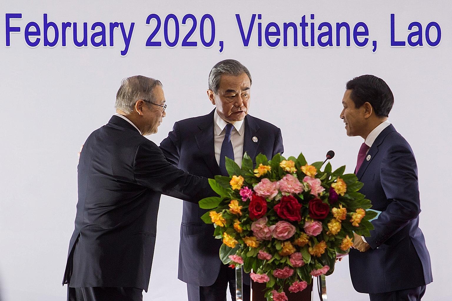 China's Foreign Minister Wang Yi (centre) with the Philippines' Secretary of Foreign Affairs Teodoro Lopez (far left) and Laos Foreign Minister Saleumxay Kommasith at a press conference after a meeting of China and Asean foreign ministers in Vientian
