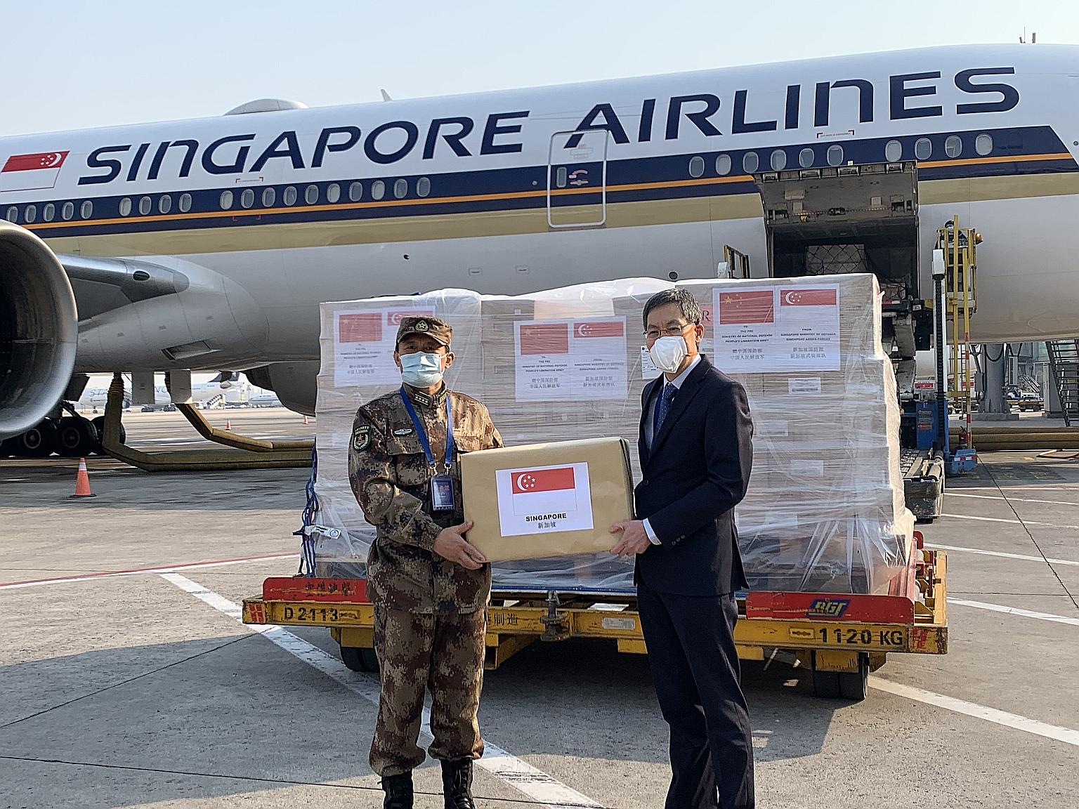 Singapore Ambassador to China Lui Tuck Yew (right) handing over the Republic's humanitarian assistance to People's Liberation Army General Hospital Medical Service Department deputy head Zhang Fu in Beijing on Wednesday.