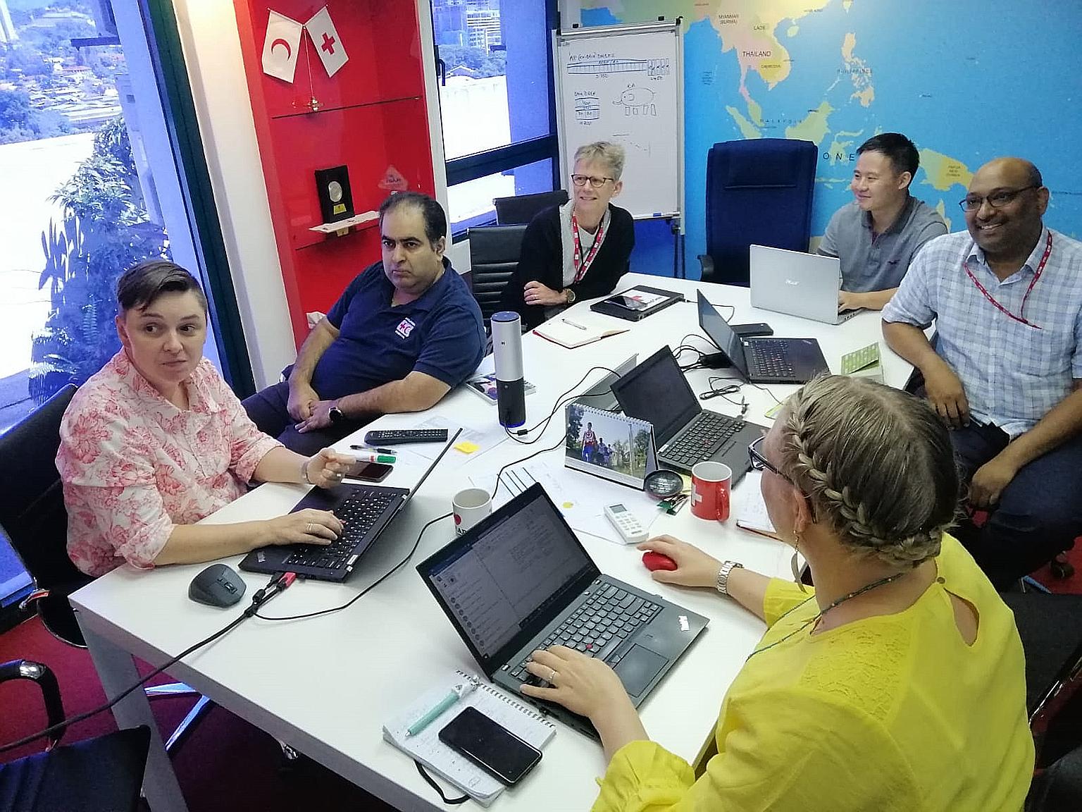 Mr Samuel Ng, manager of the Singapore Red Cross' international services, having a meeting on Wednesday with members of the Covid-19 response team at the International Federation of Red Cross and Red Crescent Societies Asia-Pacific regional office in