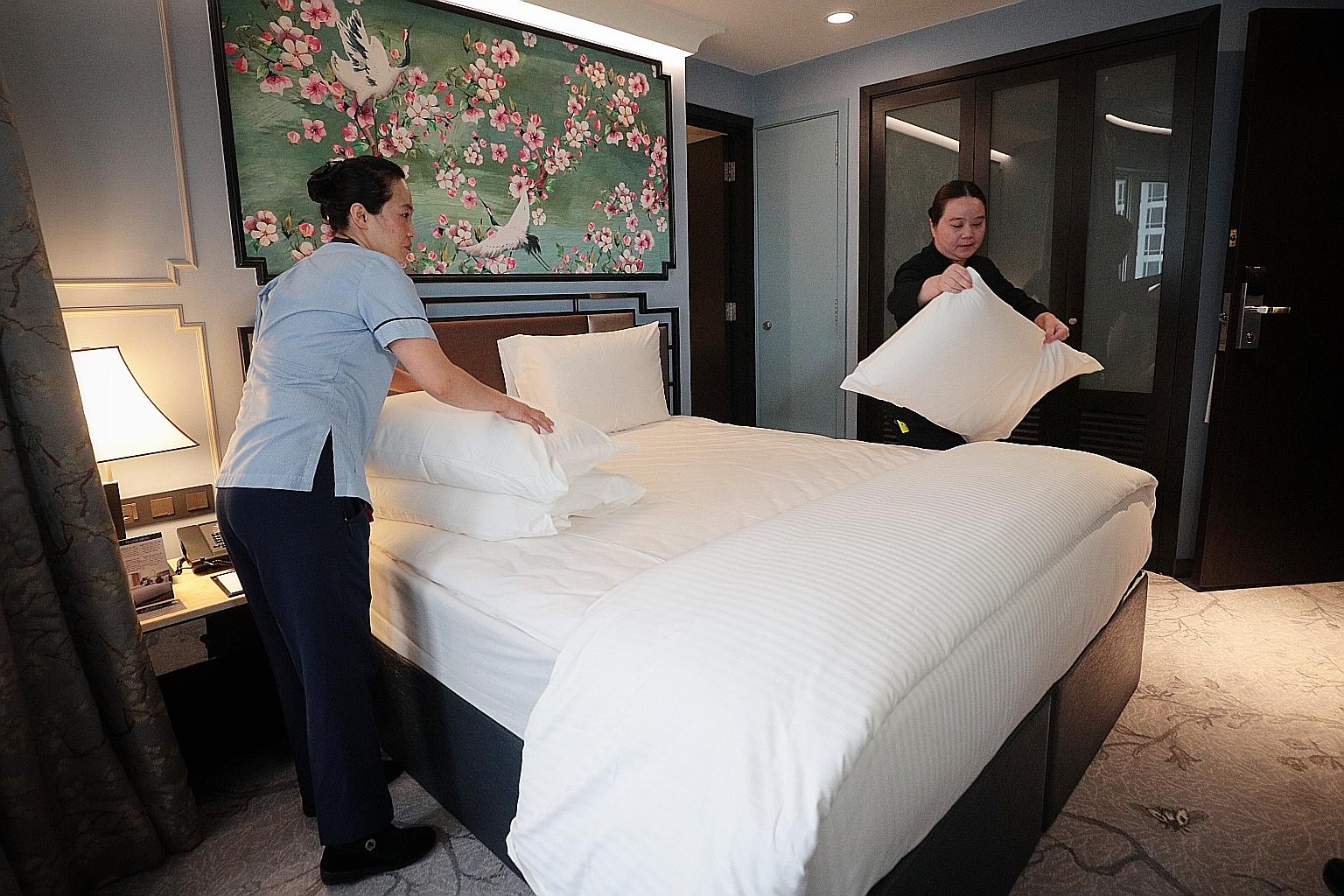 The measures to ease the impact of the coronavirus outbreak, including salary support for hotels that send staff for training, are expected to benefit those in the tourism sector like Copthorne King's Hotel's room attendant Vicky Zhang (left) and ass