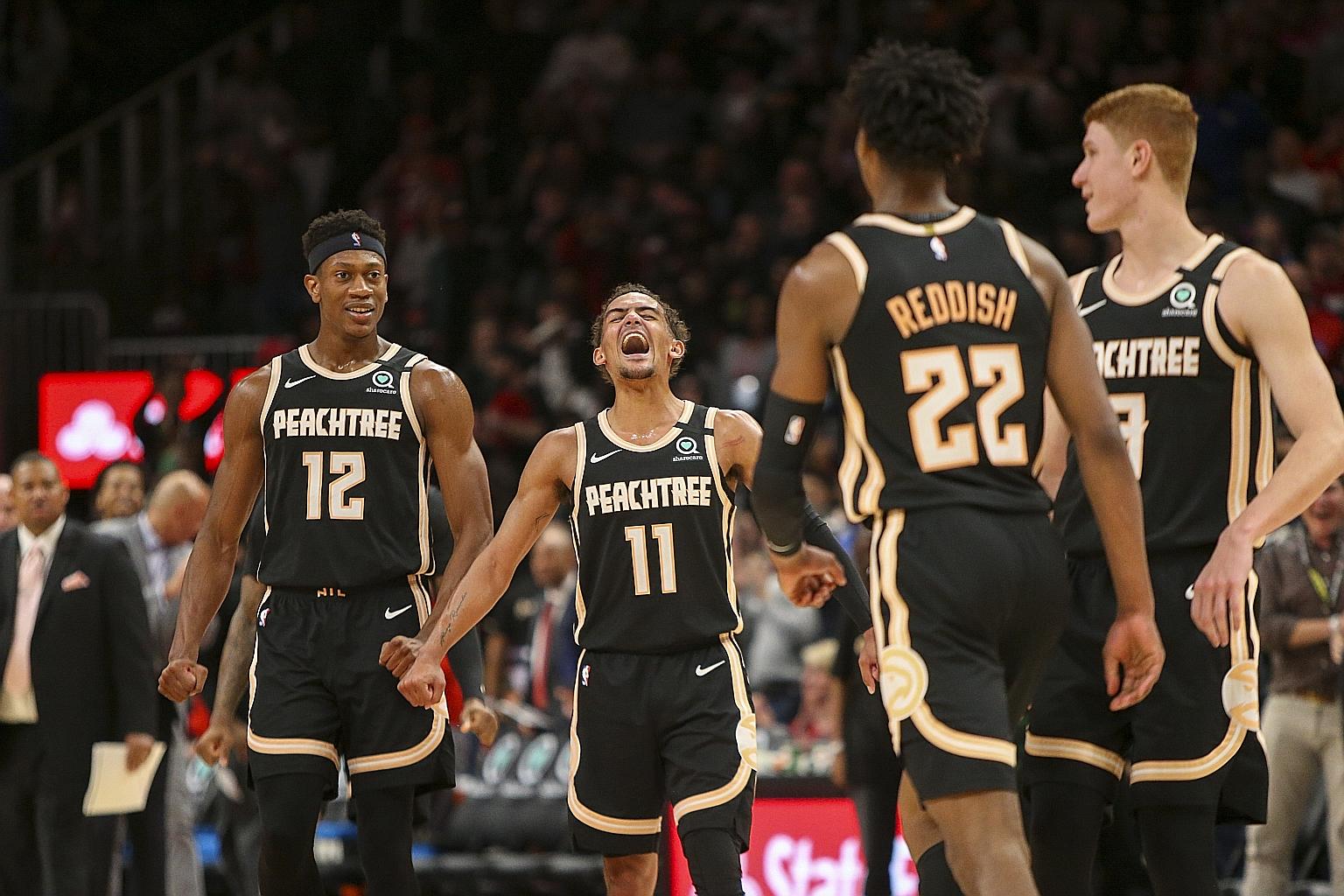Atlanta Hawks guard Trae Young (centre) celebrating with De'Andre Hunter after a basket by guard Cam Reddish against Miami Heat at the State Farm Arena. The 21-year-old became the fourth-youngest player to score 50 points after LeBron James, Devin Bo