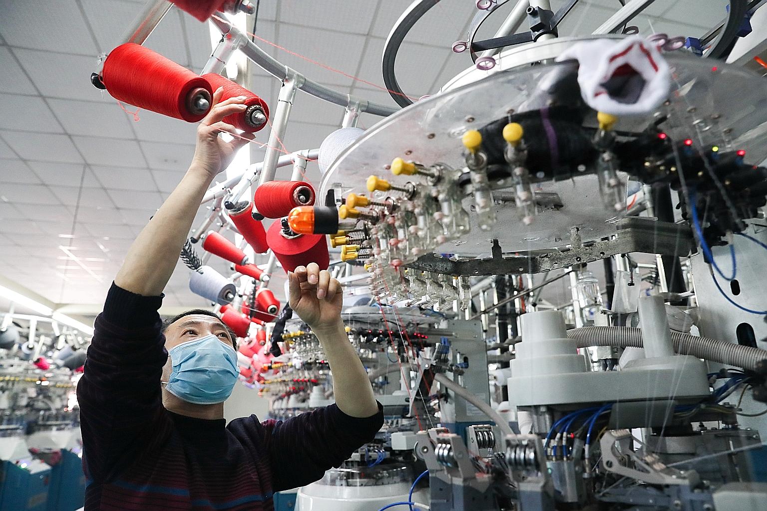 A worker at a production line making socks for export in Zhejiang province in China last week. China's share of world output has more than doubled to 19 per cent since the Sars outbreak in 2003, so the impact to global growth from the fallout in Chin